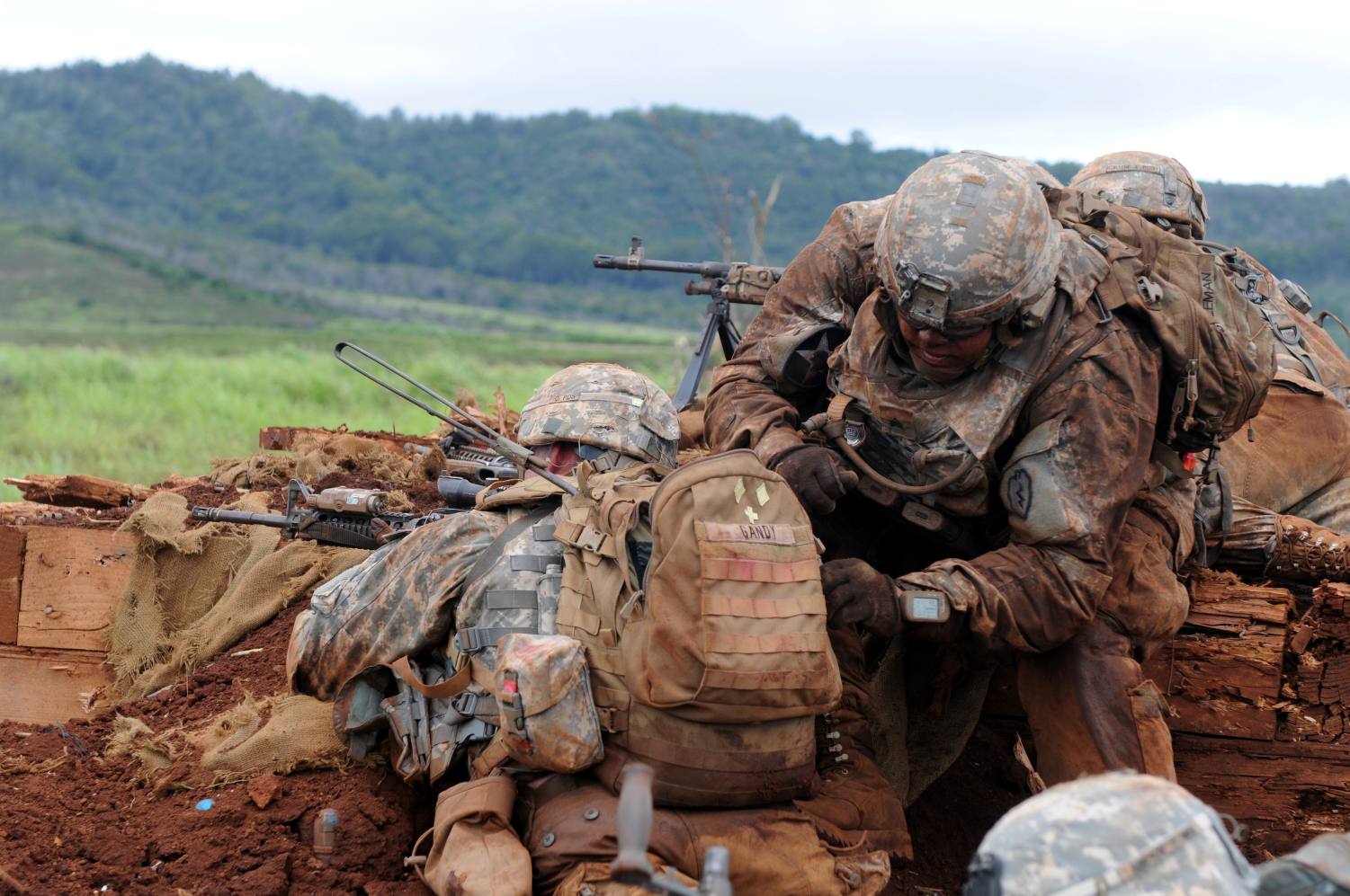 Soldiers utilizing tactical backpack in field