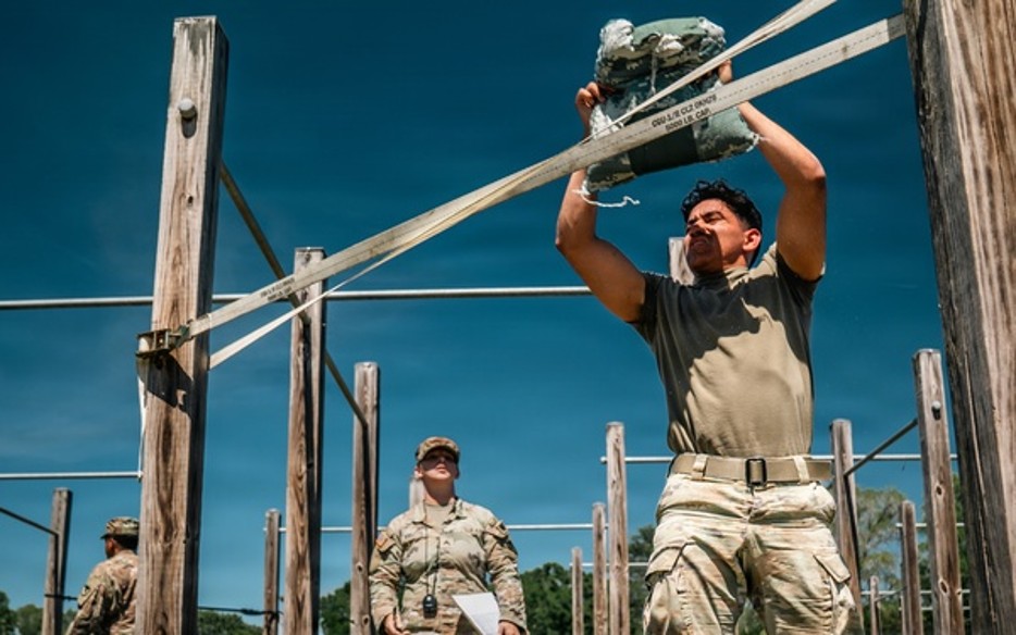 Army cadet tossing sandbag in fitness test