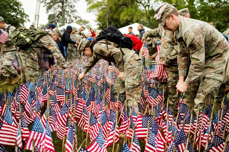 US Service members palcing flags on 9/11 memorial